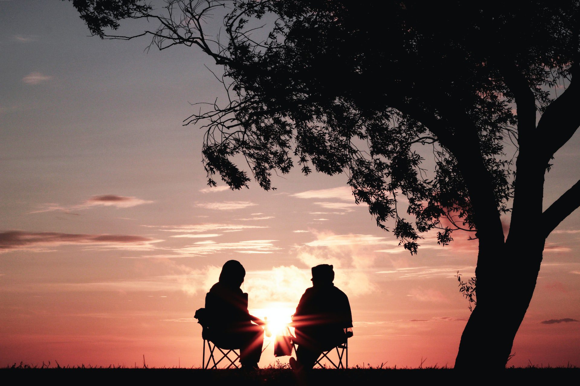 a couple sitting outside at sunset